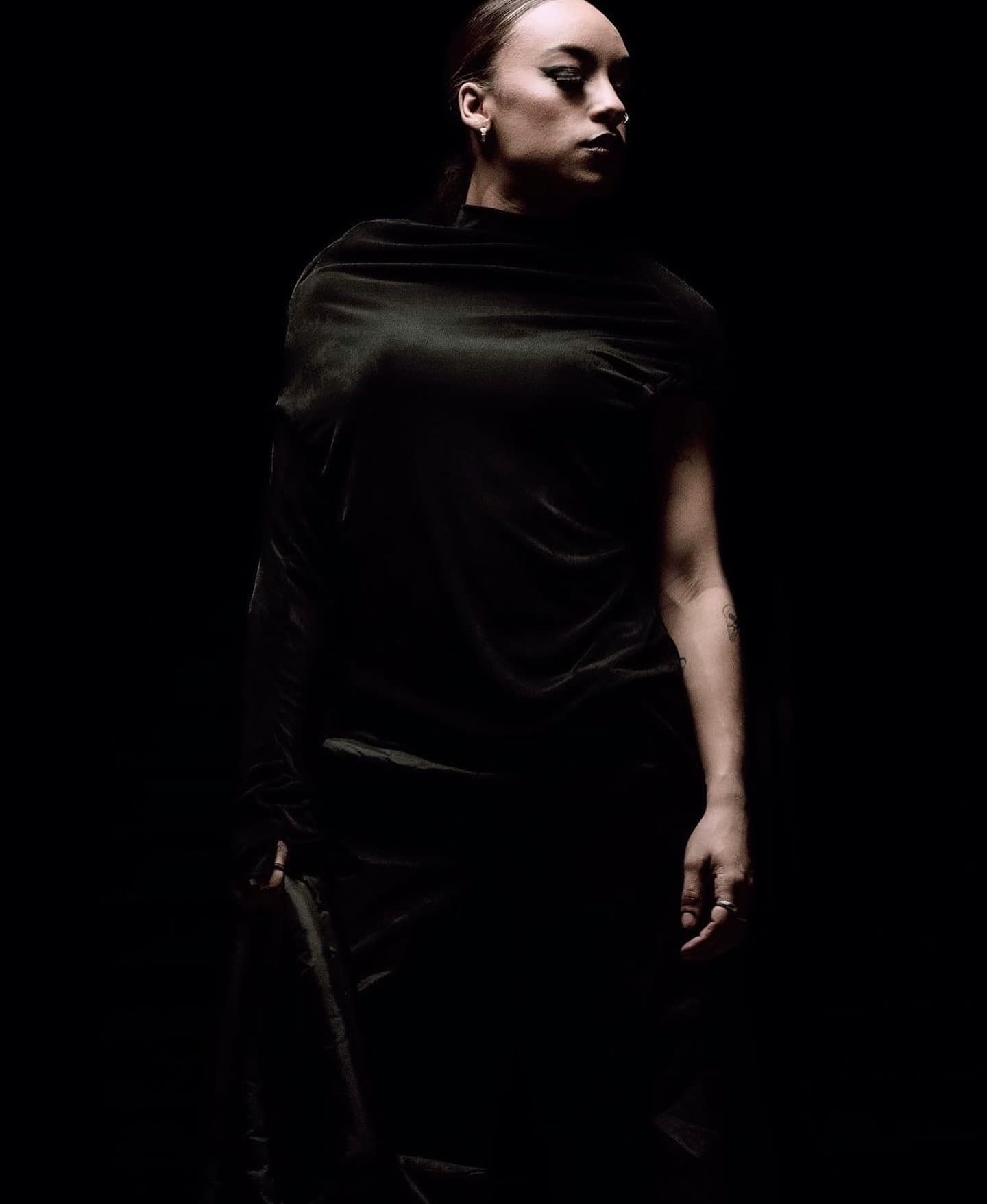Draped satin silhouette with luminous skin and a sharp winged eye
