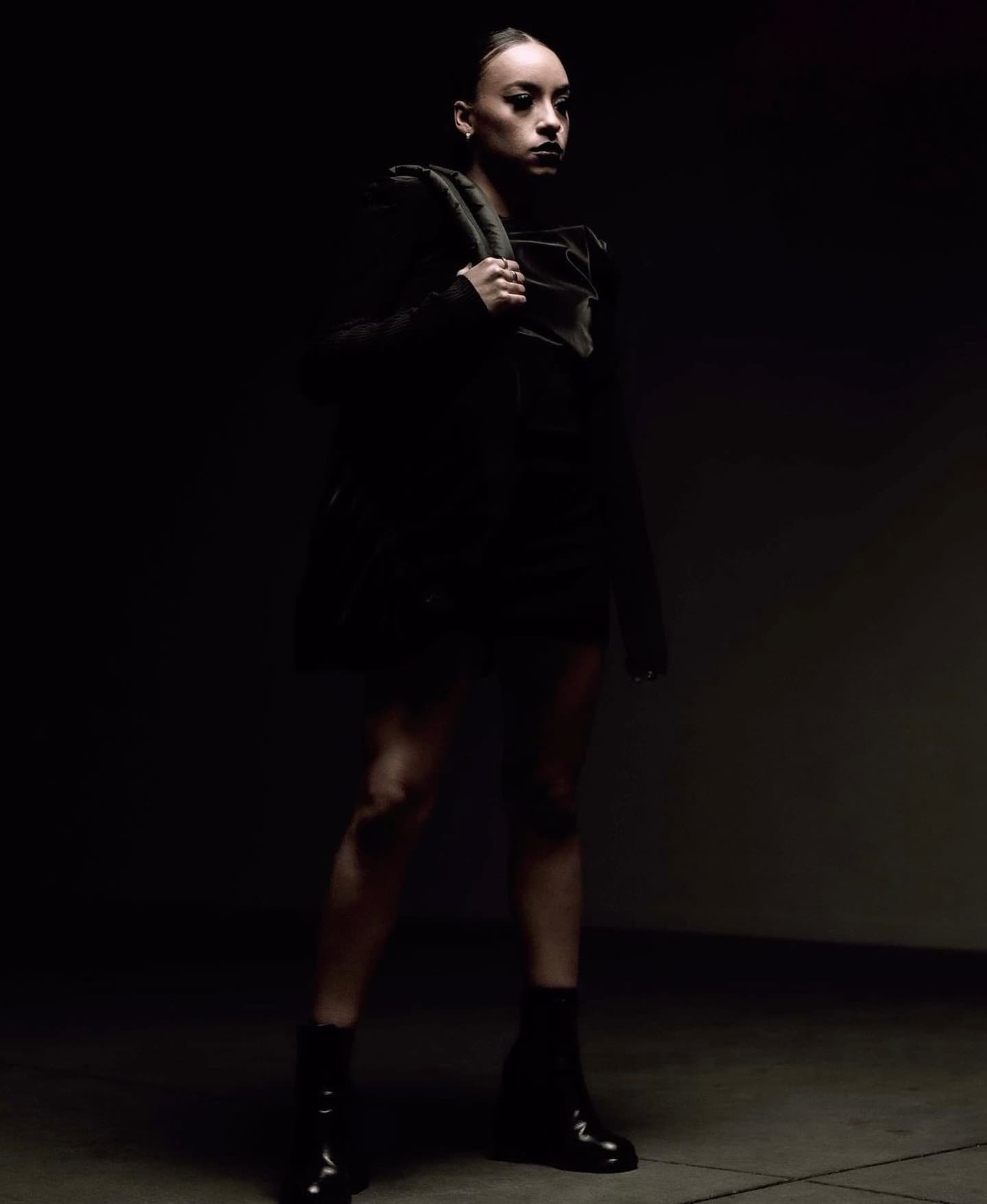 Mini dress and boots, strong brow and bold lash in low dramatic light