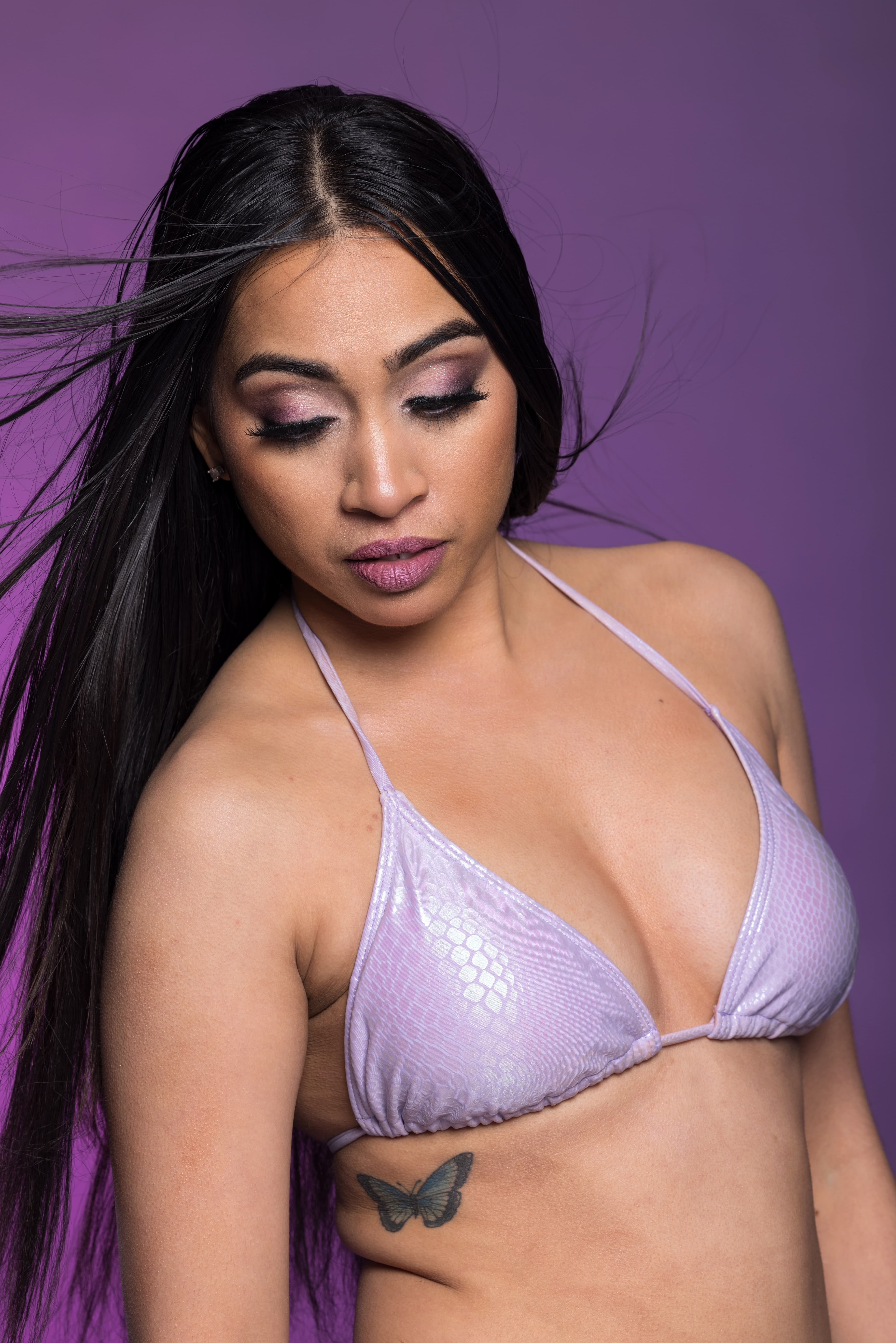 Downcast lilac beauty portrait with a shimmering violet lid and soft plum lip