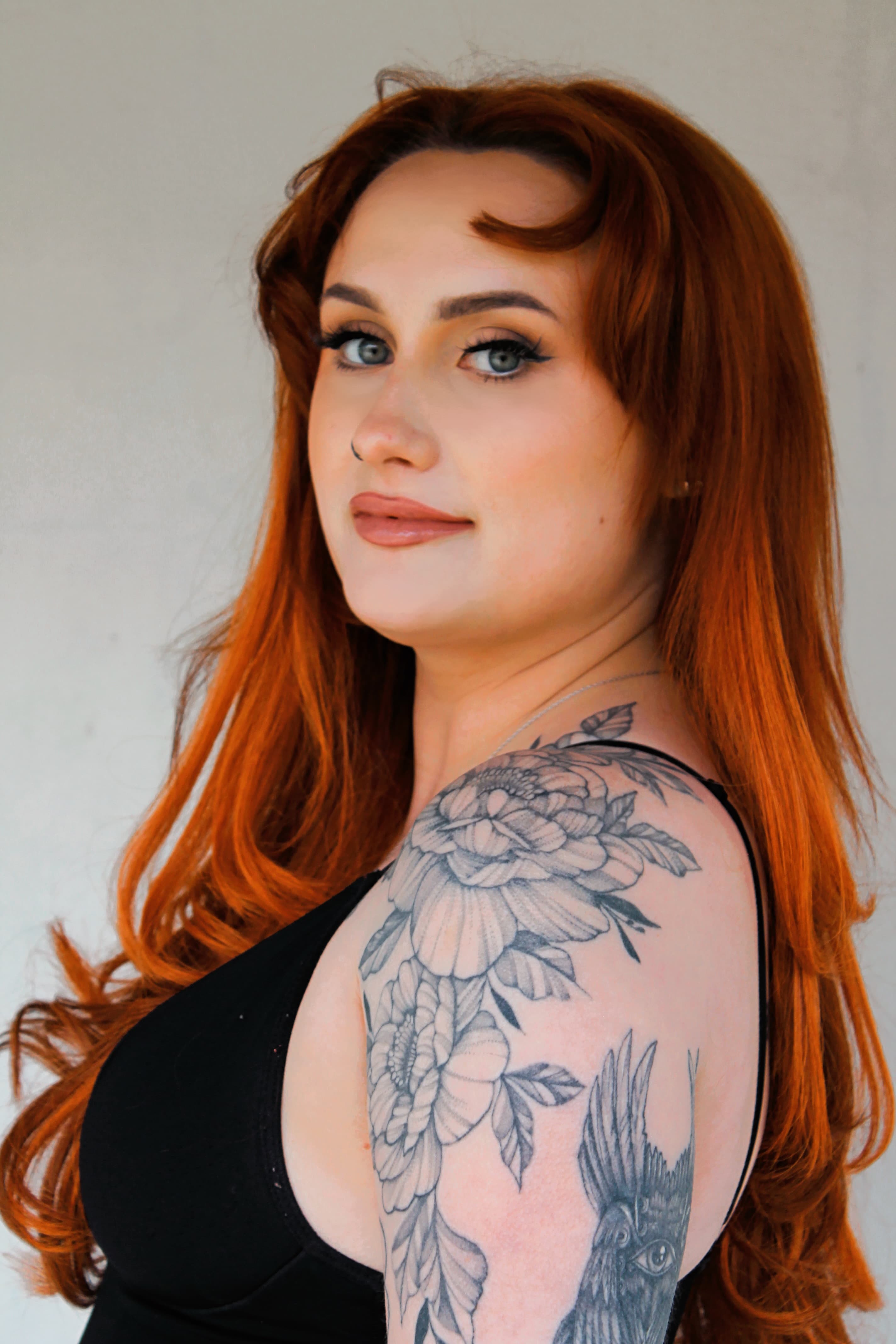Over-the-shoulder beauty portrait with luminous skin and a sharp cat eye