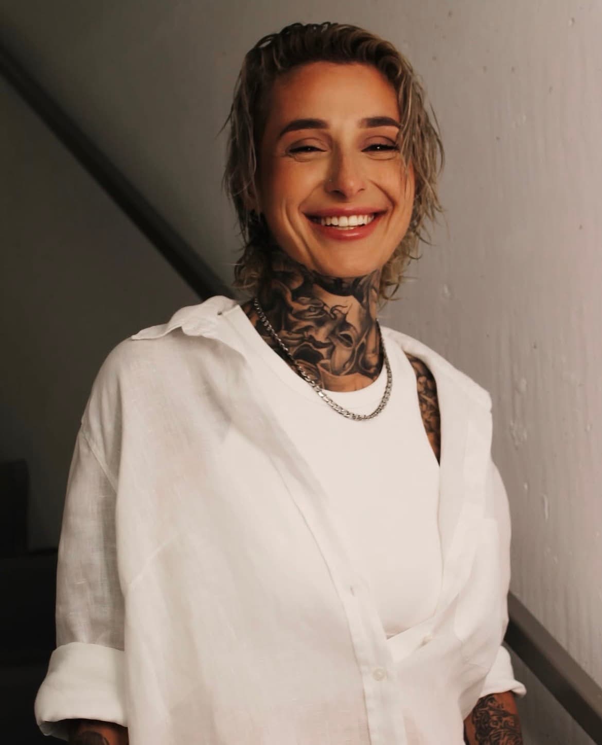 Candid laughing portrait in white linen with a fresh, luminous complexion